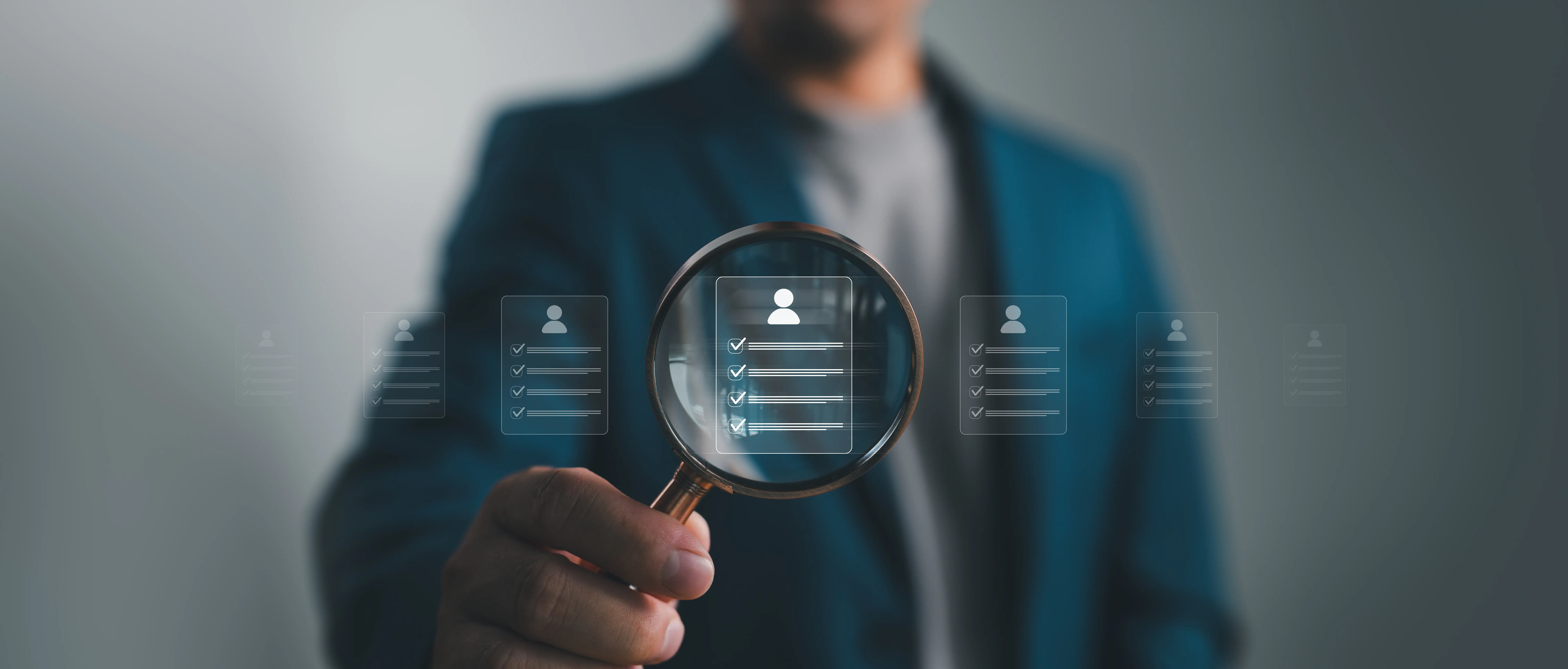 Business professional using a magnifying glass to review candidate profiles and recruitment checklist information.